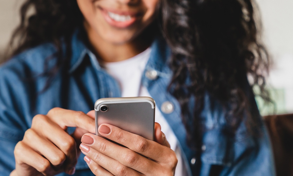 Smiling woman using mobile phone